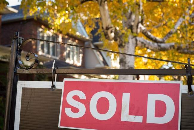A real estate sold sign hangs in front of a west-end Toronto property.