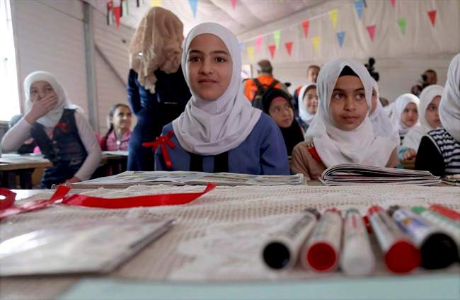 Syrian refugees pose for a photo during a visit by U.N. Secretary General Antonio Guterres to a fourth-grade classroom at the U.N.-run Zaatari camp for Syrian refugees, in northern Jordan in this March 28, 2017 file photo.