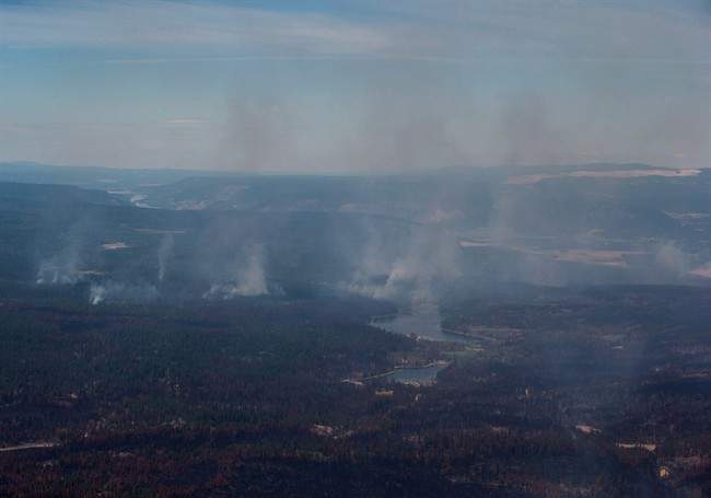 Smoke from wildfires fills the air and burned trees are seen in this aerial view from a Canadian Forces Chinook helicopter near Williams Lake, B.C., on Monday, July 31, 2017.