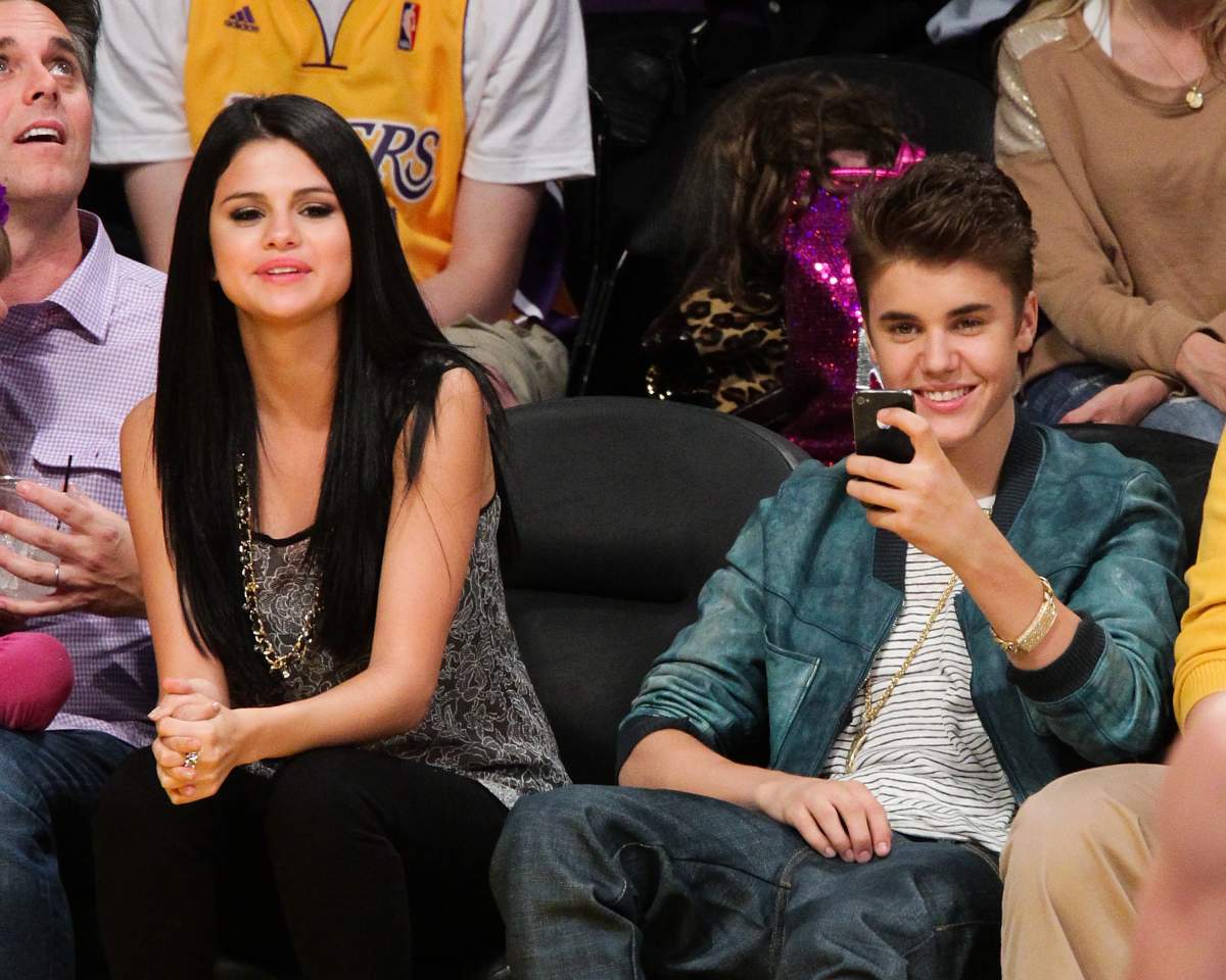 Selena Gomez (L) and Justin Bieber attend a basketball game between the San Antonio Spurs and the Los Angeles Lakers at Staples Center on April 17, 2012 in Los Angeles, Calif.