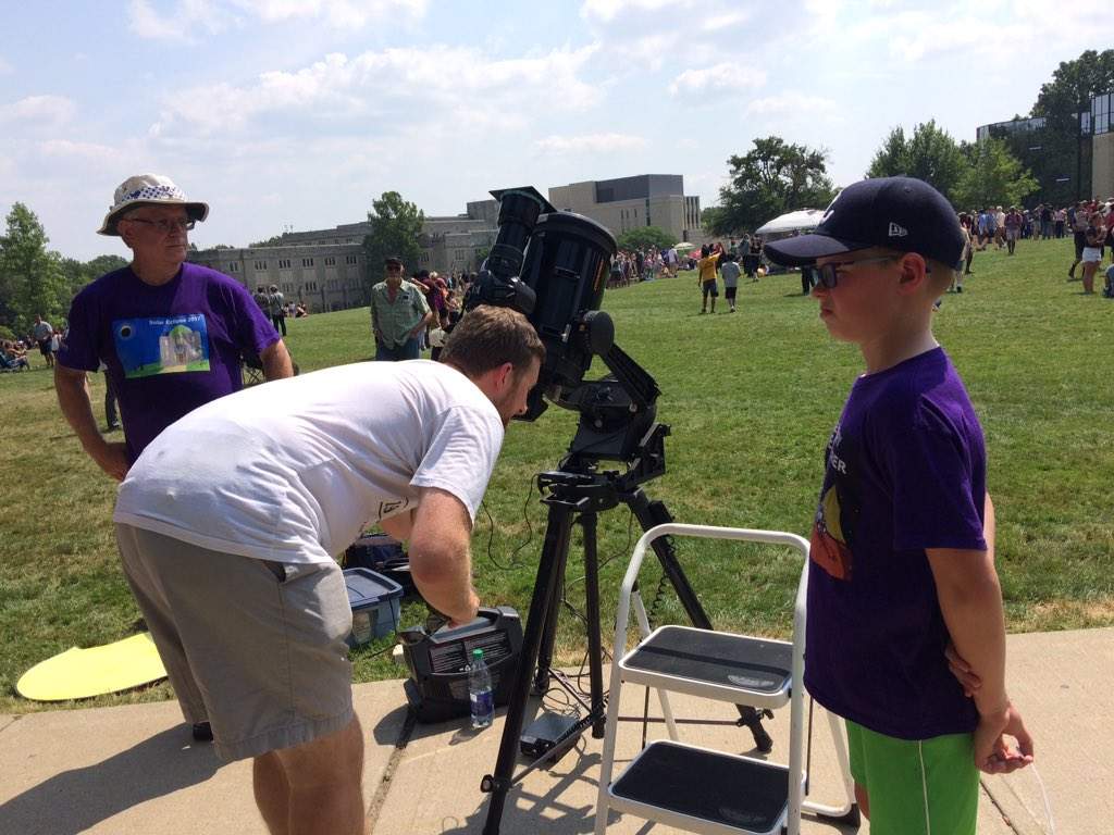 Jay Dubois and his son, Fin, use the Schmidt Cassegrain telescope under the watchful eye of amateur astronomer Dave Clark, at Western University on August 21, 2017.