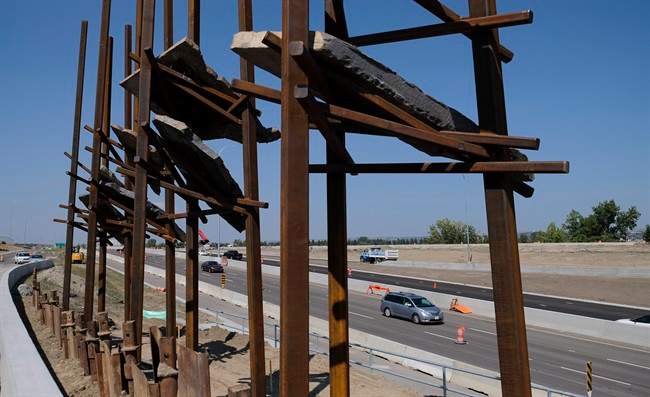 Traffic passes a sculpture by New York artist Del Geist, which is called "Bowfort Towers" and is located near Canada Olympic Park in Calgary, Alta., Wednesday, Aug. 9.