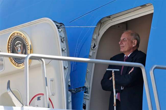 White House Chief of Staff John Kelly stands in the door of Air Force One and watches President Donald Trump, as he arrives in Reno, Nev., Wednesday, Aug. 23, 2017.