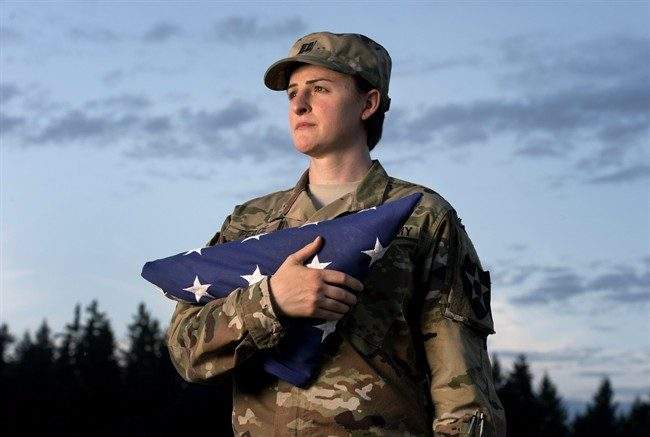 In this Aug. 28, 2015 file photo, Capt. Jennifer Peace, a transgender soldier,  holds a flag as she stands for a photo near her home in Spanaway, Wash. 