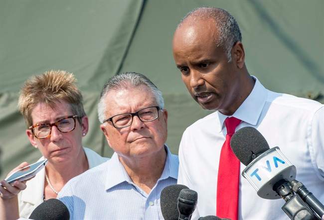 Ahmed Hussen, right, Minister of Immigration, Refugees and Citizenship, Ralph Goodale, Minister of Public Safety and Emergency Preparedness, and Brenda Shanahan, MP for Chateauguay-Lacolle, comment on the influx of asylum seekers crossing the border into Canada from the United States Monday, August 21, 2017 near Saint-Bernard-de-Lacolle, Que. THE CANADIAN PRESS/Paul Chiasson.