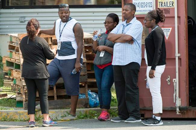Asylum seekers talk with an official in a temporary camp, Tuesday, August 15, 2017 near Saint-Bernard-de-Lacolle, Que. The camp was set up to cope with the crush of asylum seekers crossing into Canada from the United States.