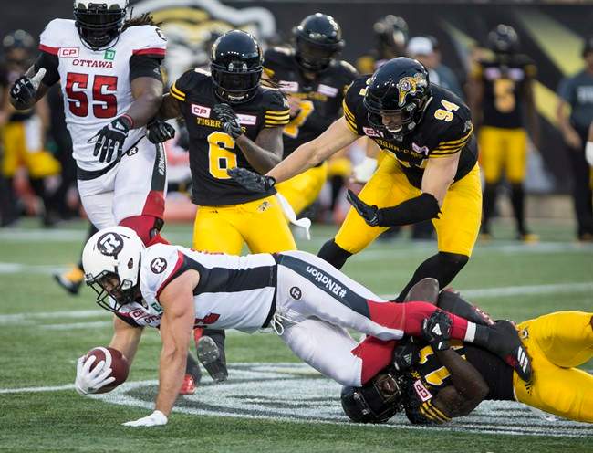 Ottawa Redblacks fullback Patrick Lavoie (81) is tackled by Hamilton Tiger-Cats linebacker Larry Dean (11) during CFL Football action in Hamilton, Ont. on Friday, August 18, 2017.