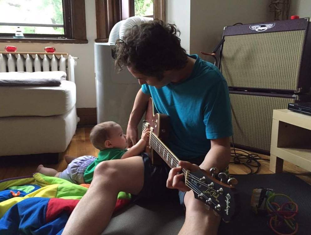 Adam Clarke plays a guitar at his home. He is turning part of a fallen tree from the intense Montreal thunderstorm into a guitar.