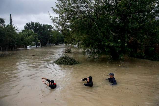 People wade through chest deep water down Pine Cliff Drive as Addicks Reservoir nears capacity due to near constant rain from Tropical Storm Harvey Tuesday, Aug. 29, 2017 in Houston.