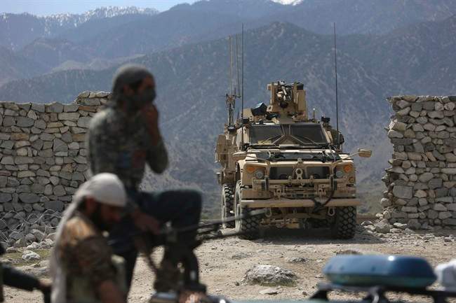 In this April 17, 2017 file photo, U.S. forces and Afghan security police are seen in Asad Khil near the site of a U.S. bombing in the Achin district of Jalalabad, east of Kabul, Afghanistan.