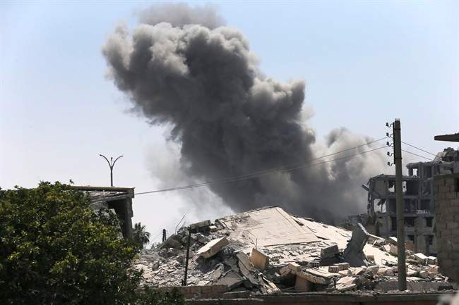 In this July 26, 2017 file photo, black smoke rises from a coalition airstrike which attacked an Islamic State militant position, on the front line on the eastern side of Raqqa, Syria.