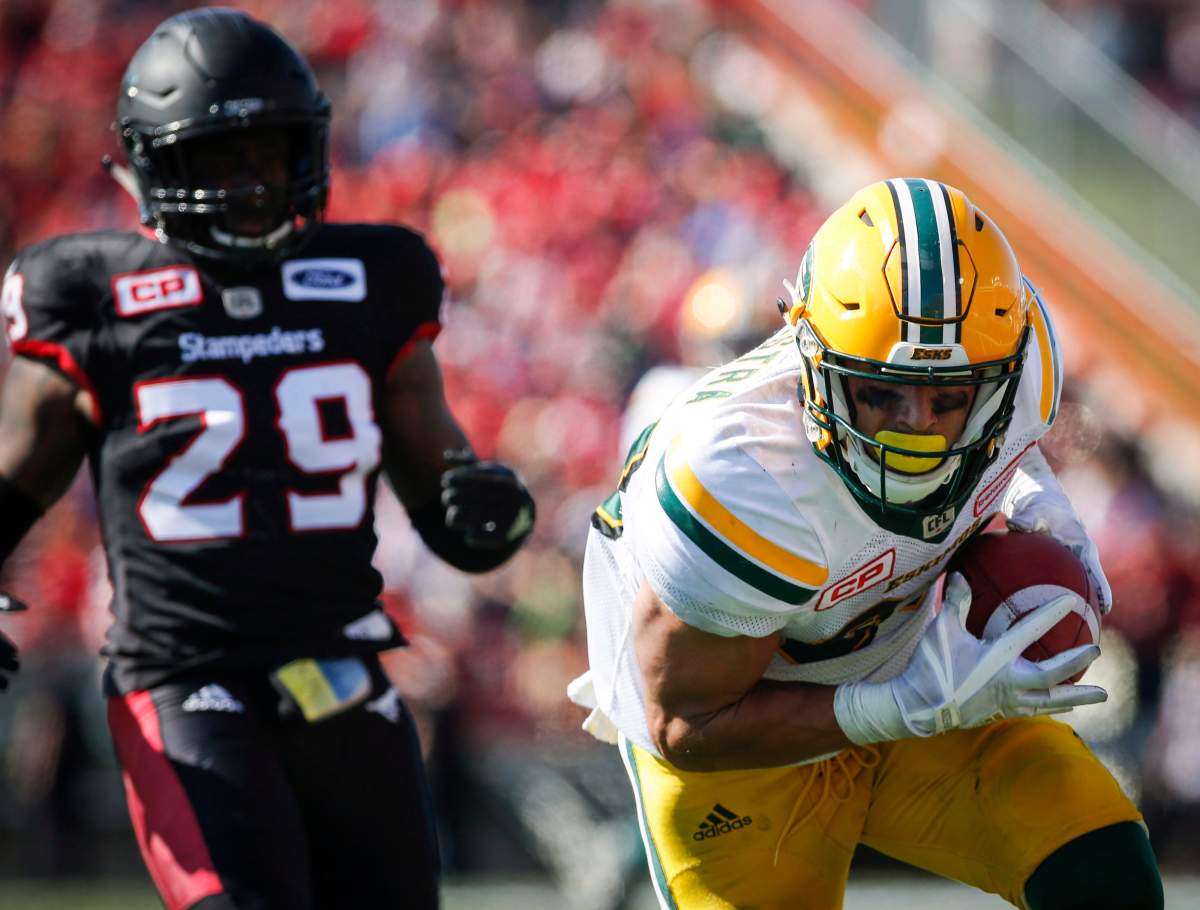 Edmonton Eskimos' Brandon Zylstra, right, catches the ball to score a touchdown as Calgary Stampeders' Jamar Wall looks on during second half CFL football action in Calgary, Monday, Sept. 4, 2017. 