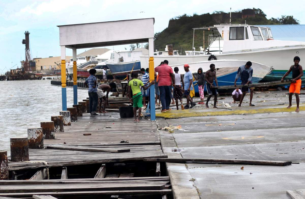 People recover broken parts of the dock after the passing of Hurricane Irma, in St. John’s, Antigua and Barbuda, Wednesday, Sept. 6, 2017.