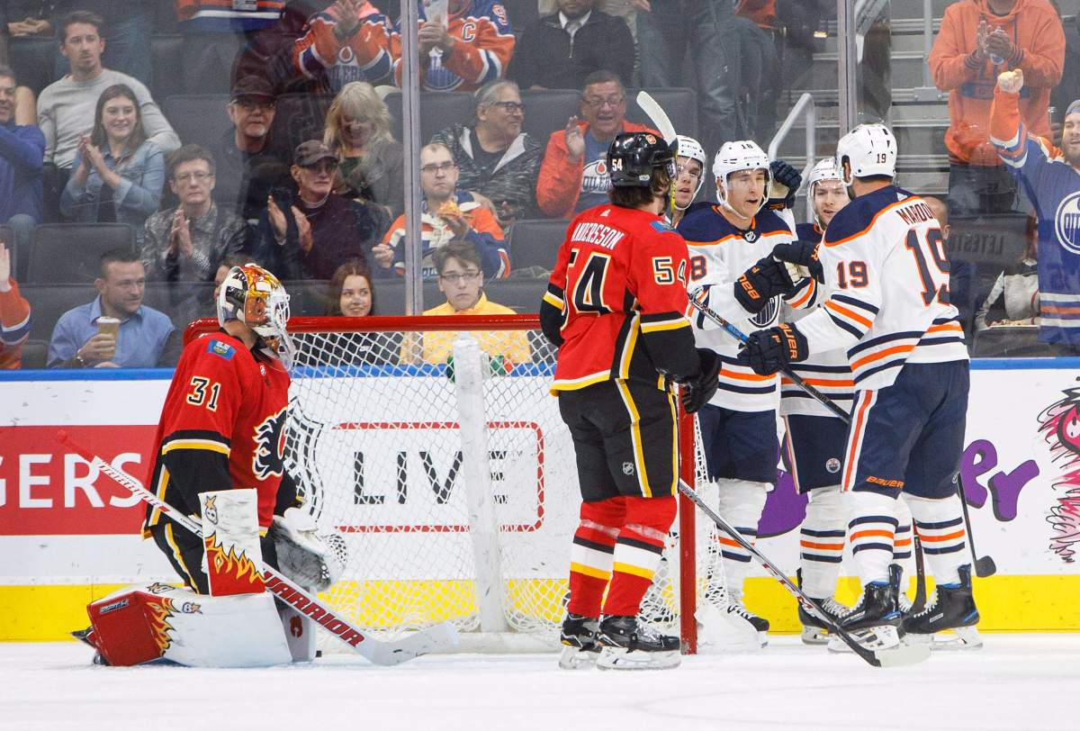 Calgary Flames goalie Eddie Lack (31) and defenceman Rasmus Andersson (54) look on as Edmonton Oilers forward Connor McDavid (97) forward Ryan Strome (18) forward Mark Letestu (55) and forward Patrick Maroon celebrate a goal during first period NHL preseason split-squad hockey action in Edmonton, Alta., on Monday September 18, 2017.