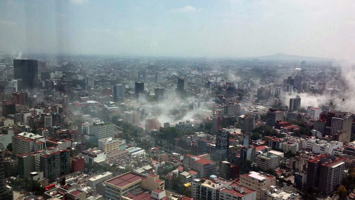 In this photo provided by Francisco Caballero Gout, shot through a window of the iconic Torre Latina, dust rises over down town Mexico City during a 7.1 earthquake, Tuesday, Sept. 19, 2017. Throughout the capital, rescuer workers and residents dug through the rubble of collapsed buildings seeking survivors. (Francisco Caballero Gout via AP)