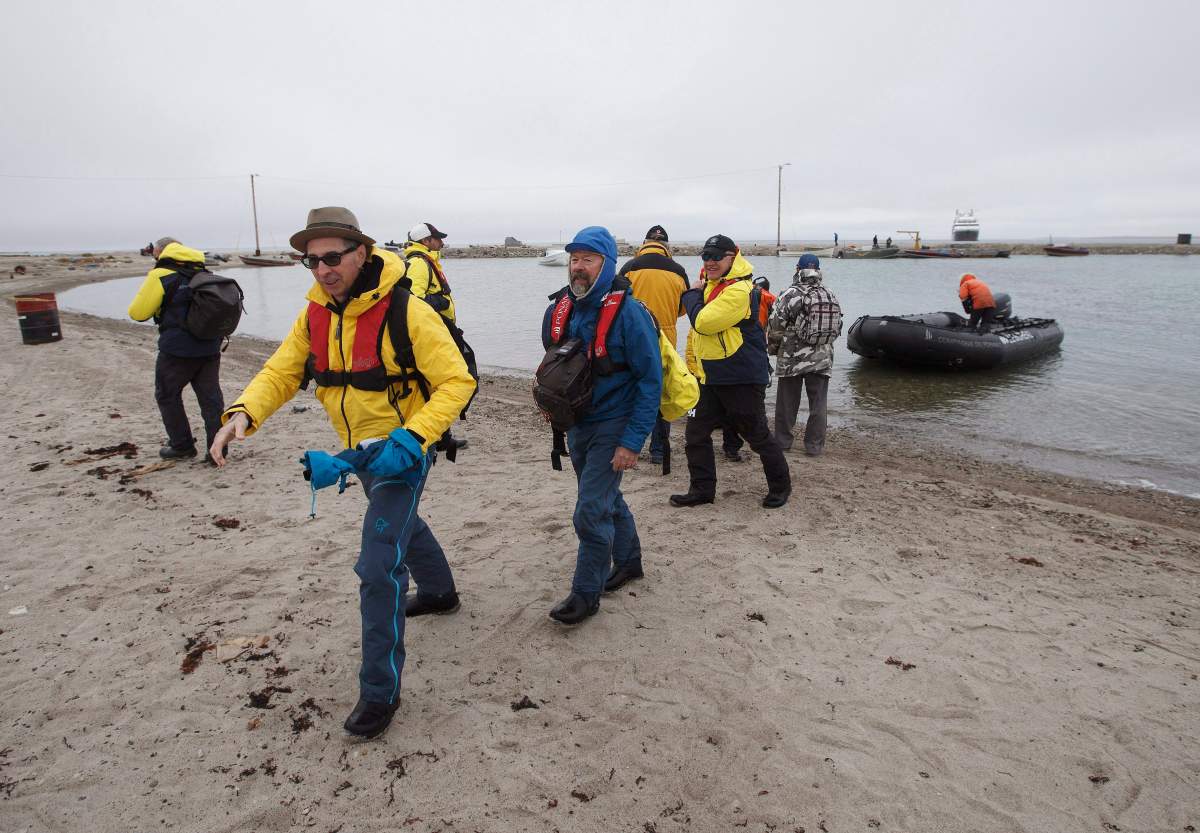 Tourists get off a Zodiac after leaving a cruise ship in the bay of Gjoa Haven, Nunavut on Saturday September 3, 2017.