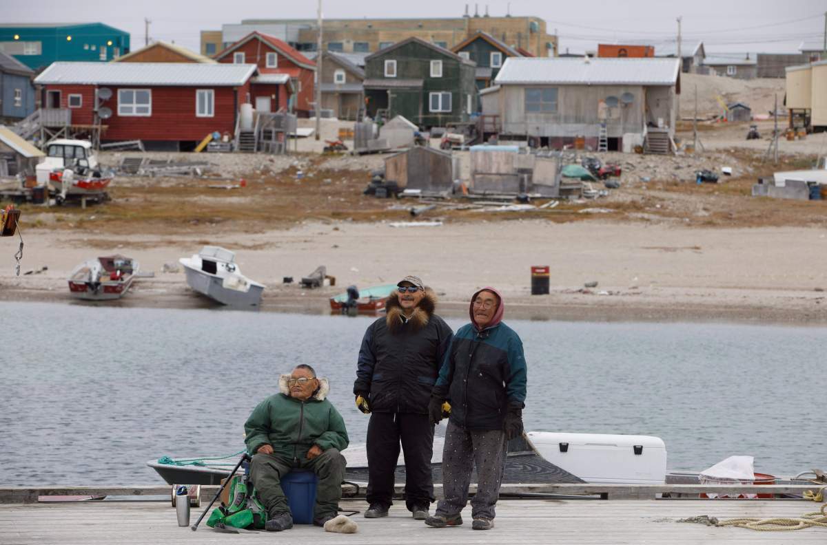 Residents watch as a cruise ship unloads tourists in the town of Gjoa Haven, Nunavut on Saturday September 3, 2017.