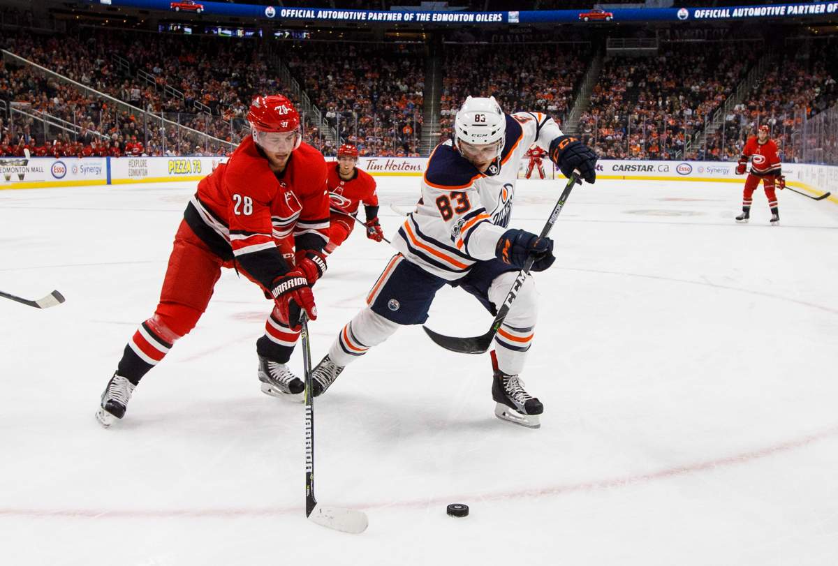 Carolina Hurricanes’ Elias Lindholm, of Sweden, (28) and Edmonton Oilers’ Matthew Benning (83) battle for the puck during first period preseason NHL action in Edmonton, Alta., on Monday September 25, 2017. THE CANADIAN PRESS/Jason Franson