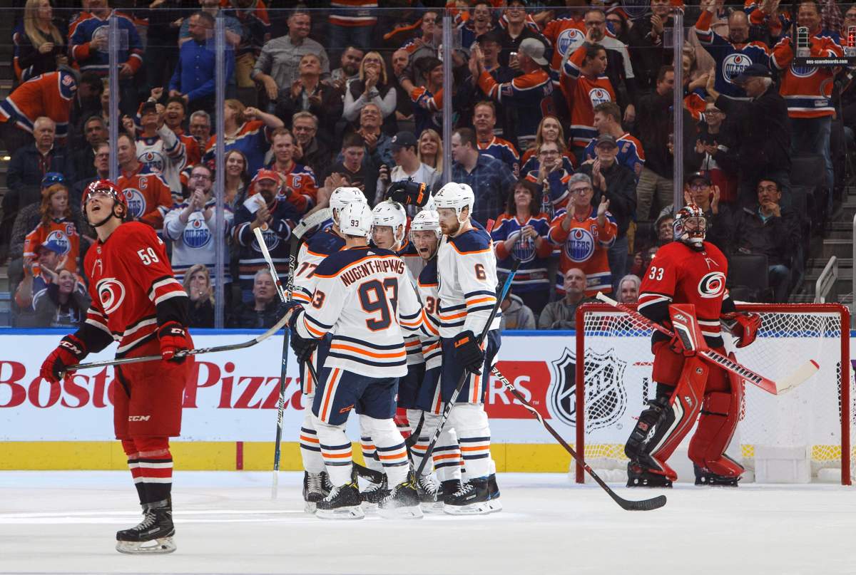 Carolina Hurricanes’ Janne Kuokkanen, of Finland, (59) and goalie Scott Darling (33) look on as the Edmonton Oilers celebrate a goal during first period preseason NHL action in Edmonton, Alta., on Monday September 25, 2017. THE CANADIAN PRESS/Jason Franson