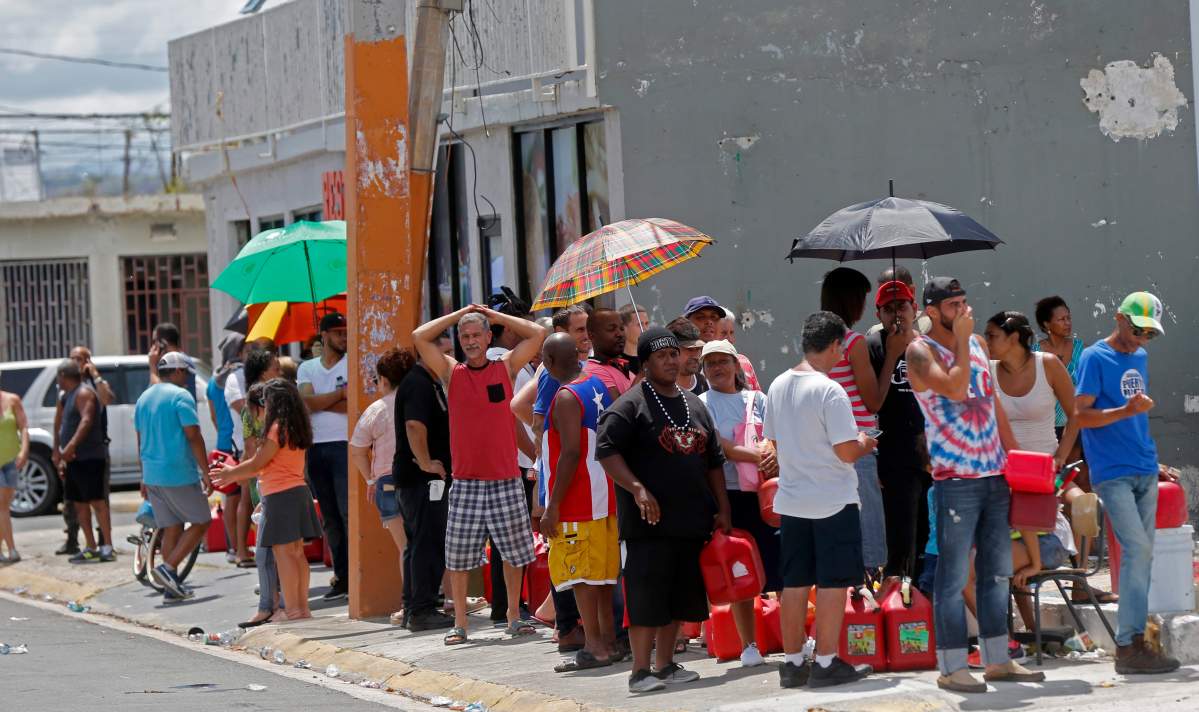 People line up with gas cans to get fuel from a gas station, in the aftermath of Hurricane Maria, in San Juan, Puerto Rico, Monday, Sept. 25, 2017.
