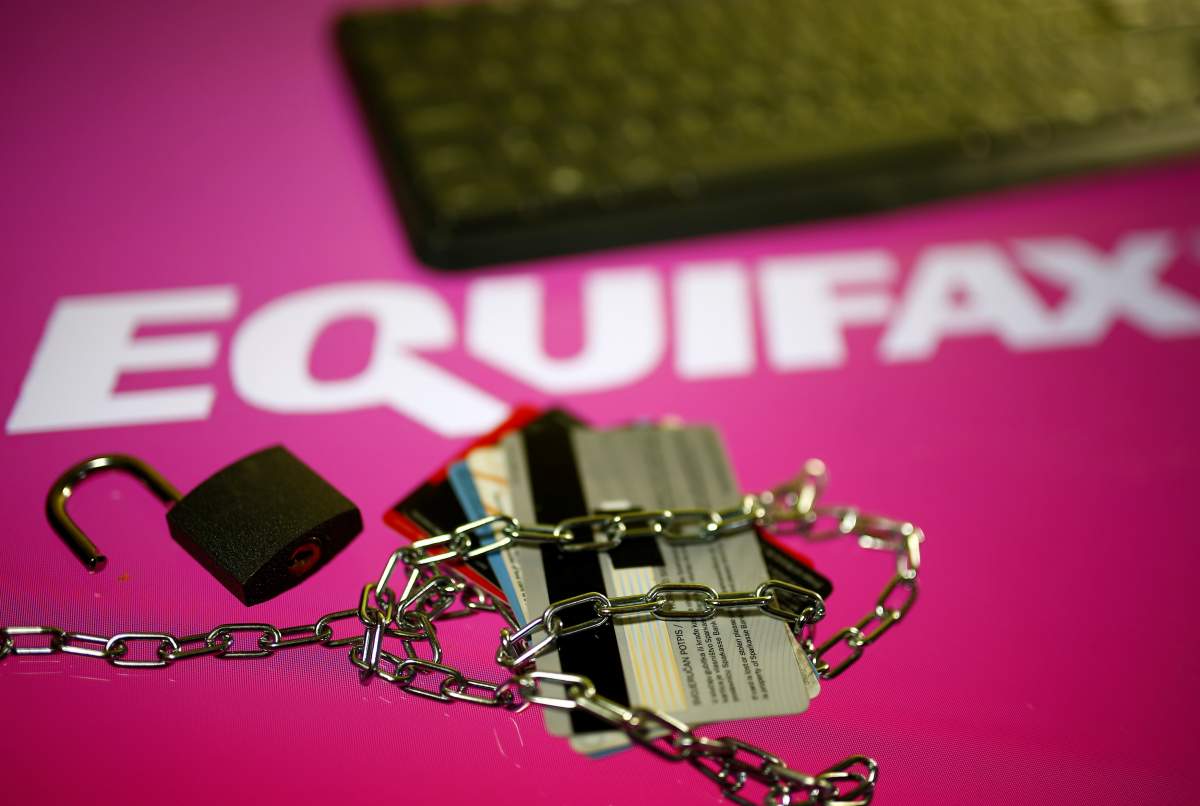 Credit cards, a chain and an open padlock is seen in front of displayed Equifax logo in this illustration taken September 8, 2017.