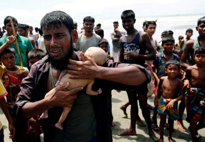 Nasir Ahmed, a Rohingya refugee man, cries as he holds his 40-day-old son, who died as a boat capsized.