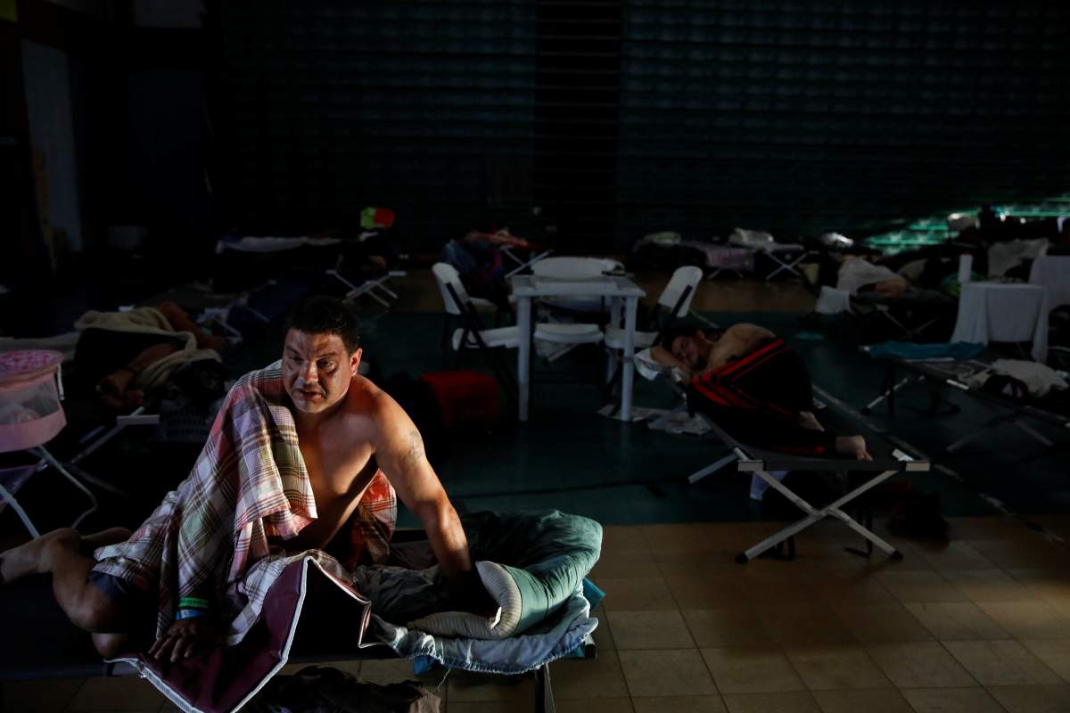 Carlos Cruz (L) wakes up after sleeping in a shelter set up at the Pedrin Zorrilla coliseum after the area was hit by Hurricane Maria in San Juan, Puerto Rico, September 25, 2017.