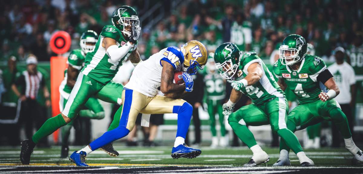 Darvin Adams (1) of the Winnipeg Blue Bombers and Kacy Rodgers II (45) and Jeff Hecht (24) of the Saskatchewan Roughriders during the game at New Mosaic Stadium in Regina, SK, Saturday, July 1st, 2017. (Photo: Johany Jutras)
