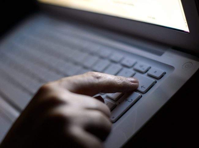 File photo dated 06/08/13 of someone using a laptop. A Saskatoon man has been charged by the Saskatchewan ICE unit with downloading and sharing child pornography.