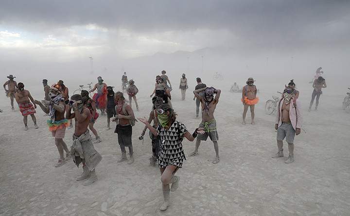 Burning Man participants dance in the midst of a driving desert dust storm on the 2nd day of the annual Burning Man arts and music festival in the Black Rock Desert of Nevada, August 29, 2017.