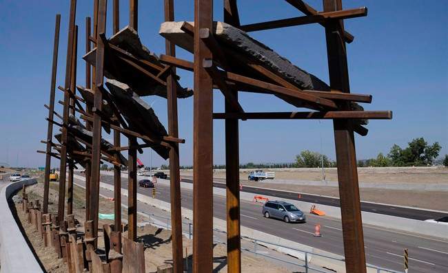 Traffic passes a sculpture by New York artist Del Geist, which is called "Bowfort Towers" and is located near Canada Olympic Park in Calgary on Aug. 9, 2017.