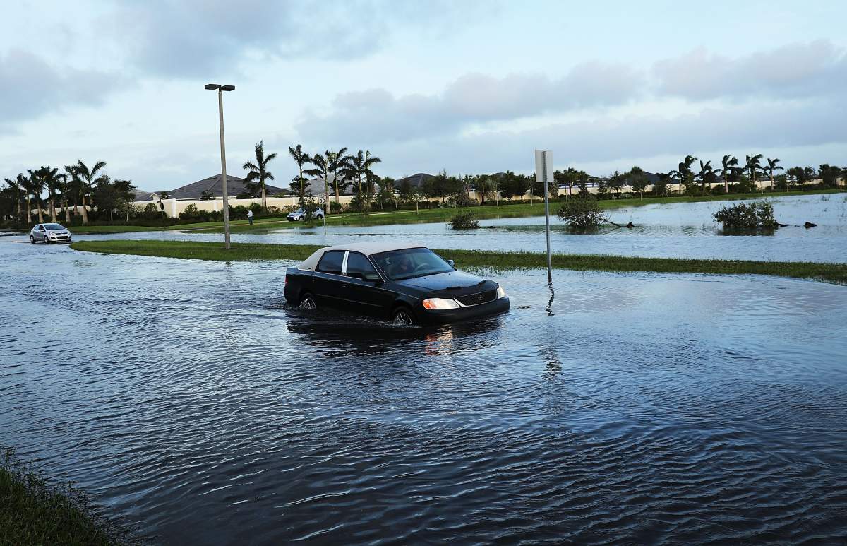 Cars make their away through a flooded street the morning after Hurricane Irma swept through the area on September 11, 2017 in Bonita Springs, Florida.