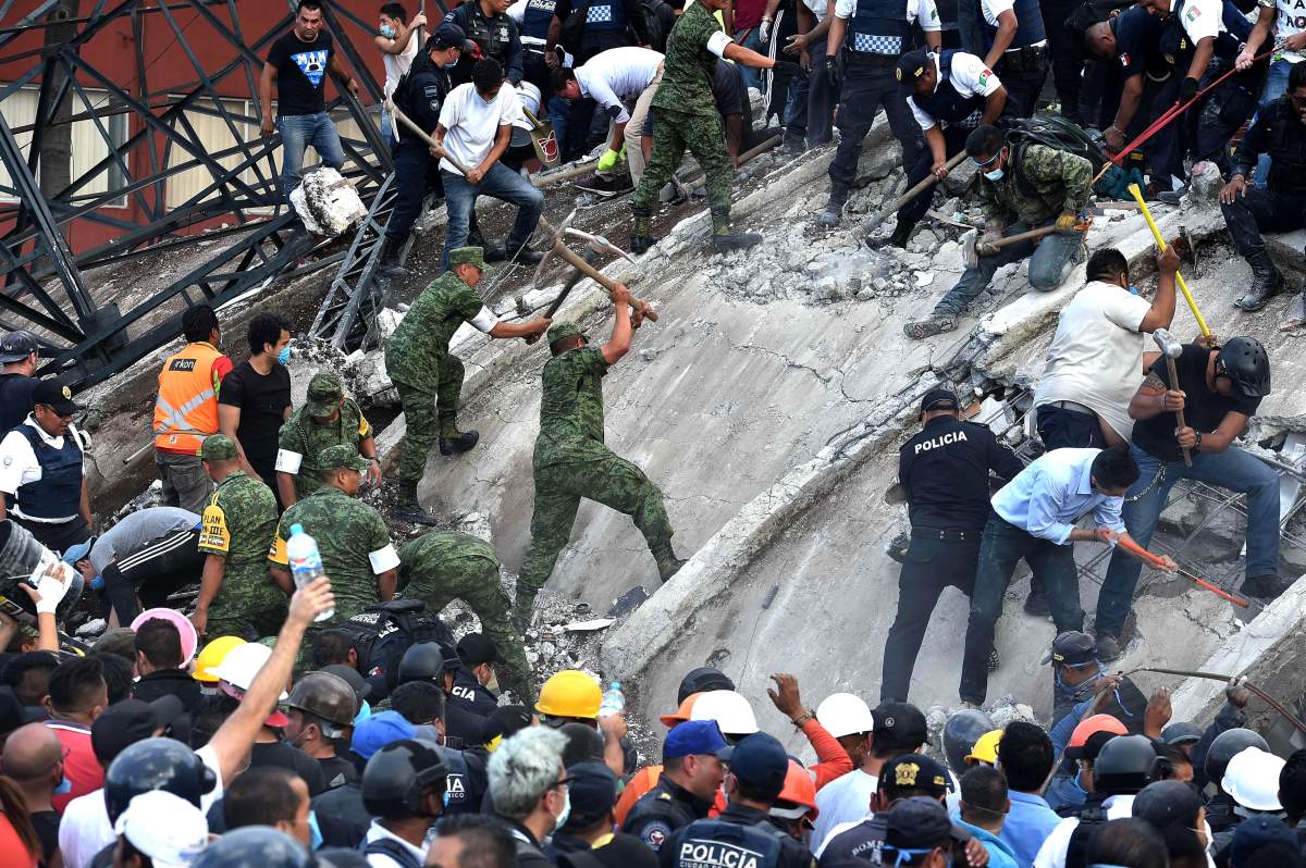 Rescuers, firefighters, policemen, soldiers and volunteers remove rubble and debris from a flattened building in search of survivors after a powerful quake in Mexico City on September 19, 2017.A devastating quake in Mexico on Tuesday killed more than 100 people, according to official tallies, with a preliminary 30 deaths recorded in the capital where rescue efforts were still going on. / AFP PHOTO / YURI CORTEZ (Photo credit should read YURI CORTEZ/AFP/Getty Images)