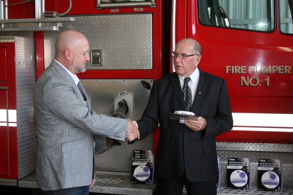 Don Armitage, Enbridge presents OSM Reeve Dave Nelson with a combination smoke/carbon monoxide alarm during the event at the OSM Fire Hall Sept. 11.