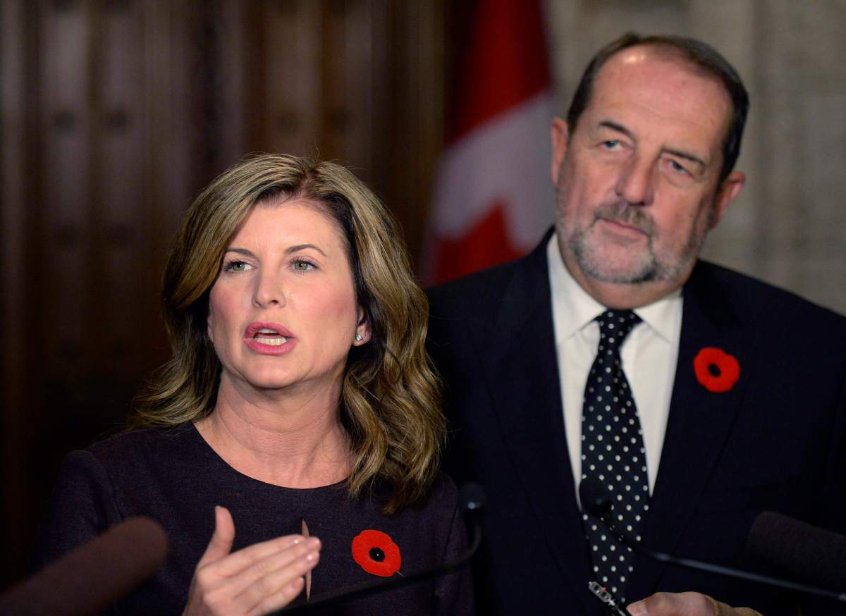 Former interim Conservative leader Rona Ambrose speaking to reporters following the tabling of the Fall Economic Statement, as fomer Conservative MP Denis Lebel looks on, on Parliament Hill, Tuesday, Nov. 1, 2016 in Ottawa.