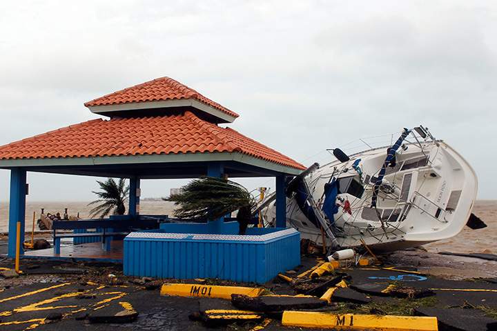 A sail boat lies over a pier in Fajardo as Hurricane Maria hits Puerto Rico on September 20, 2017.