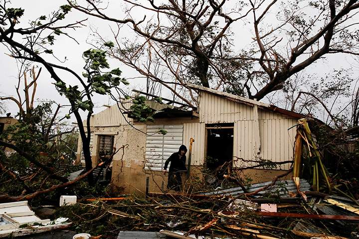 A man pictured outside a damaged home in Guayama, Puerto Rico after the island was hit by Hurricane Maria, September 20, 2017.