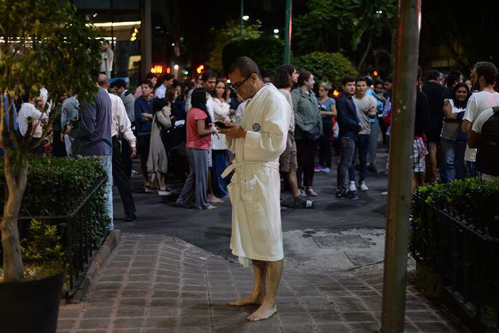 People gather on a street in downtown Mexico City following an earthquake on September 7, 2017.