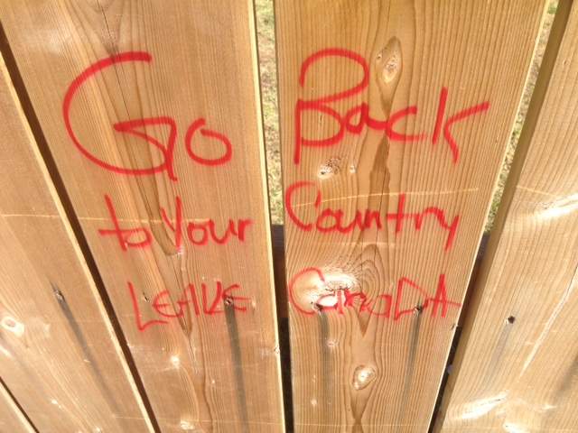 Racist graffiti on a fence outside the home of Syrian refugee family's home in Winnipeg.