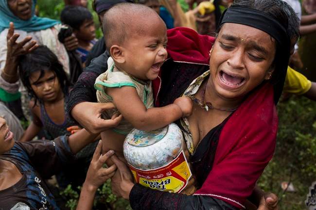 In this Sept. 8, 2017, photo, a Rohingya woman breaks down after a fight erupted during food distribution by local volunteers at Kutupalong, Bangladesh, Friday, Sept. 8, 2017.
