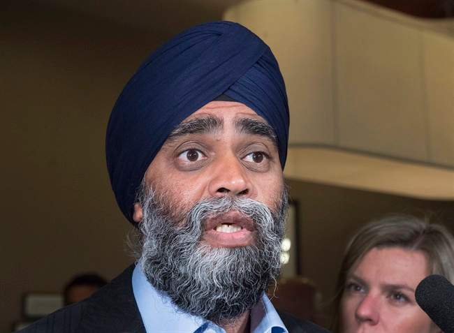 Defence Minister Harjit Sajjan talks with reporters on the way to the morning session as the Liberal cabinet meets in St. John's, N.L. on Wednesday, Sept. 13, 2017.