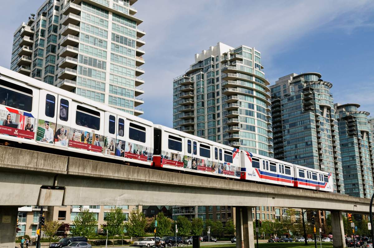 SkyTrain light rapid transit cars on a section of elevated track between the Stadium-Chinatown and Main Street-Science World stations, Vancouver, B.C., May 1, 2014. In the background are several high-rise condominium towers between Quebec Street and Main Street.