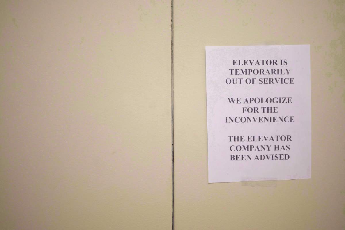 A sign is taped to a door of an elevator in a downtown Toronto office building on July 13, 2016. 