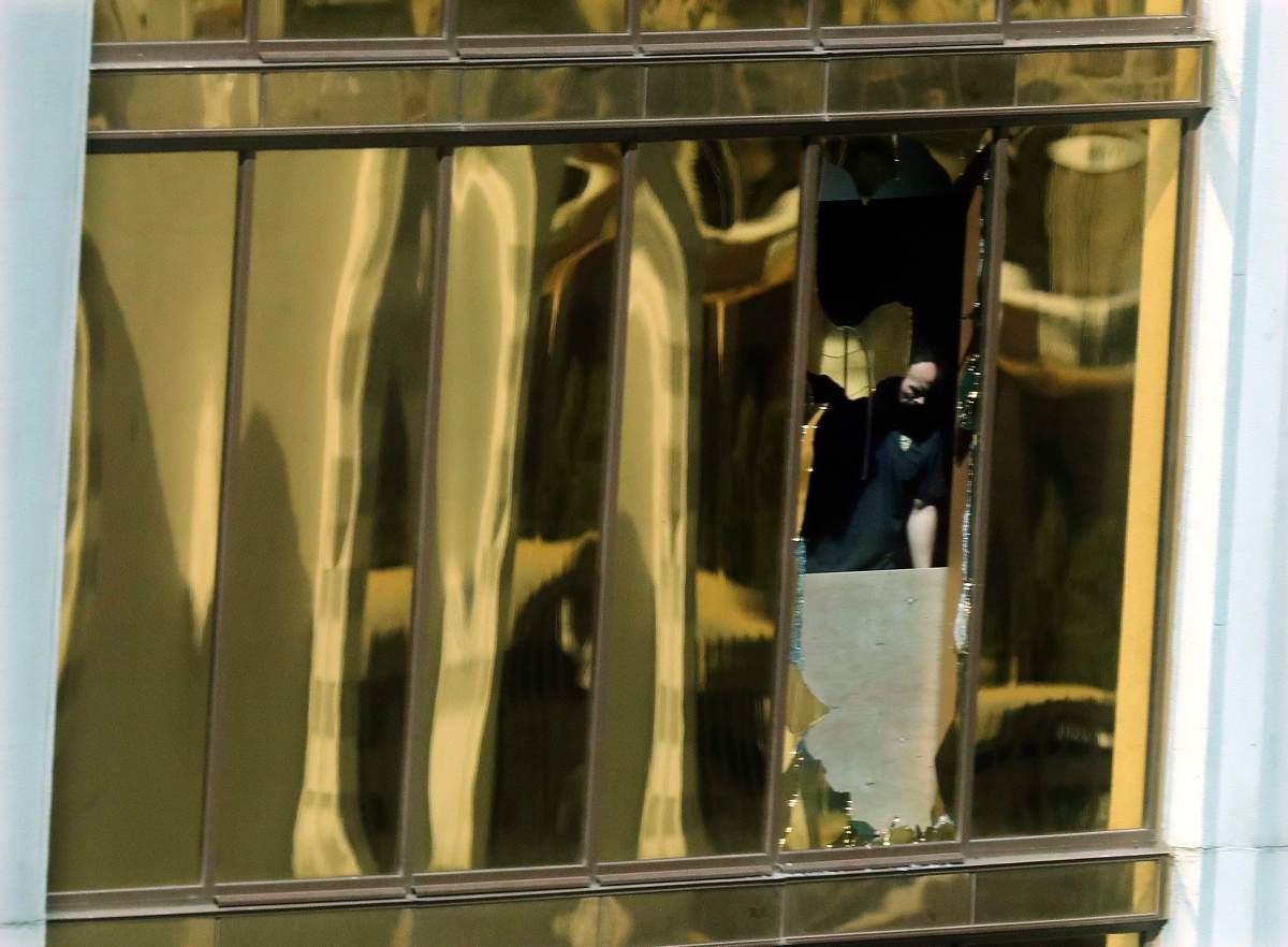 An investigator works in the room at the Mandalay Bay Resort and Casino where a gunman opened fire from on a music festival Tuesday, Oct. 3, 2017, in Las Vegas. The gunman killed dozens and injuring hundreds at the festival.
