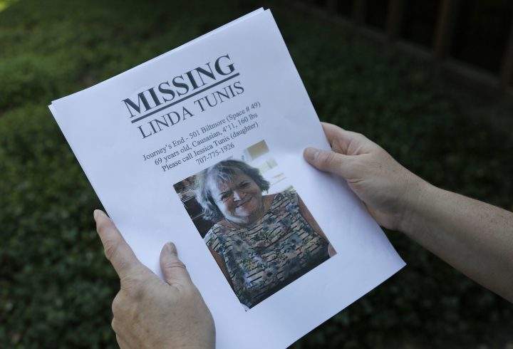 Jessica Tunis stands outside a Red Cross evacuation center and holds a flyer about her missing mother on Oct. 11, 2017, in Santa Rosa, Calif.