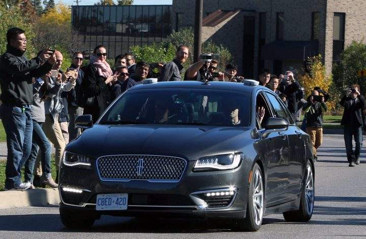 People watch as an autonomous car drives down an Ottawa street as the City of Ottawa and Blackberry QNX demonstrate the vehicle on Oct. 12, 2017.