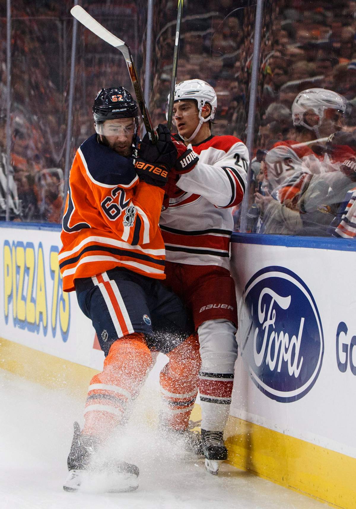 Carolina Hurricanes’ Sebastian Aho (20) is checked by Edmonton Oilers’ Eric Gryba (62) during first period NHL action in Edmonton, Alta., on Tuesday, October 17, 2017.