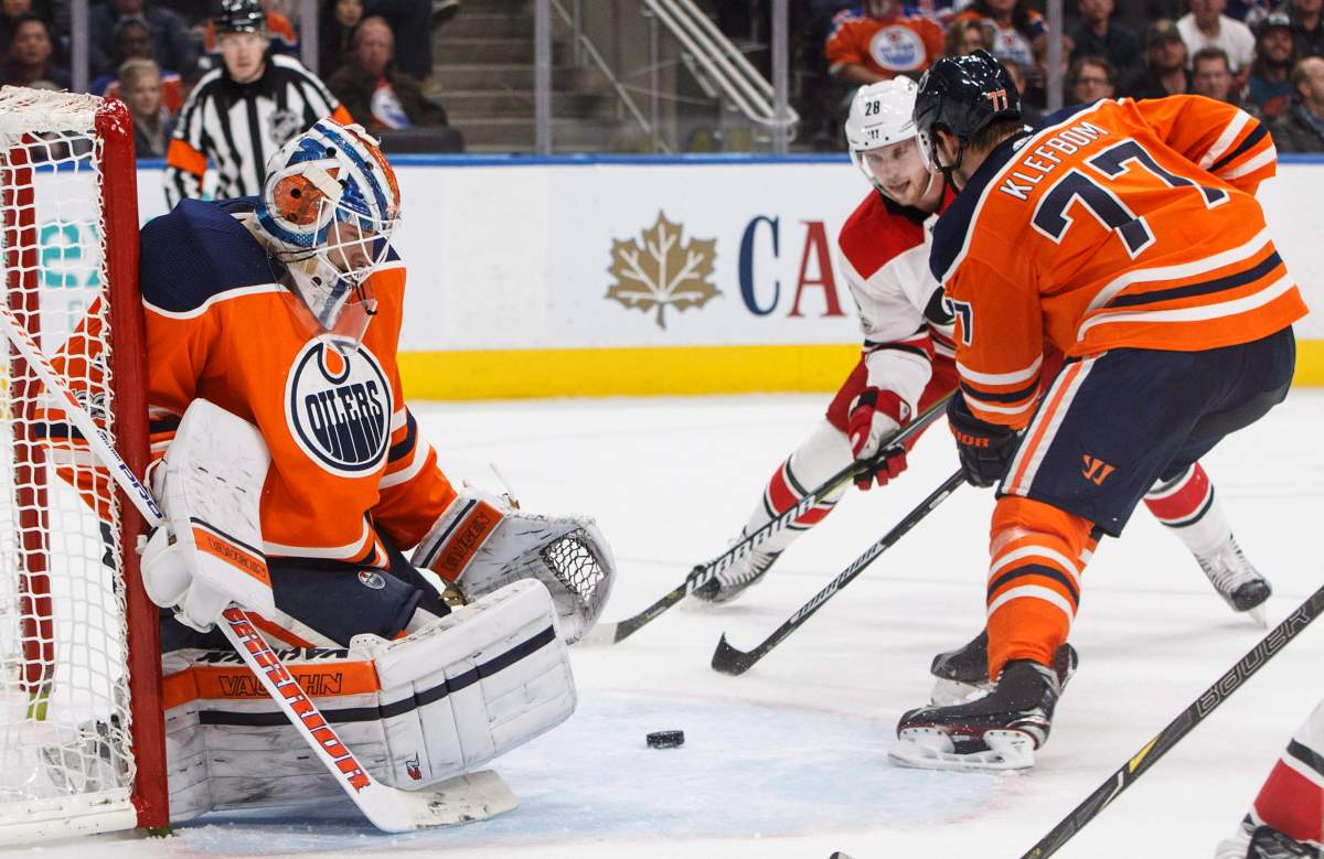 Carolina Hurricanes Elias Lindholm (28) looks for the rebound from Edmonton Oilers goalie Laurent Brossoit (1) as Oscar Klefbom (77) defends during first period NHL action in Edmonton, Alta., on Tuesday, October 17, 2017.