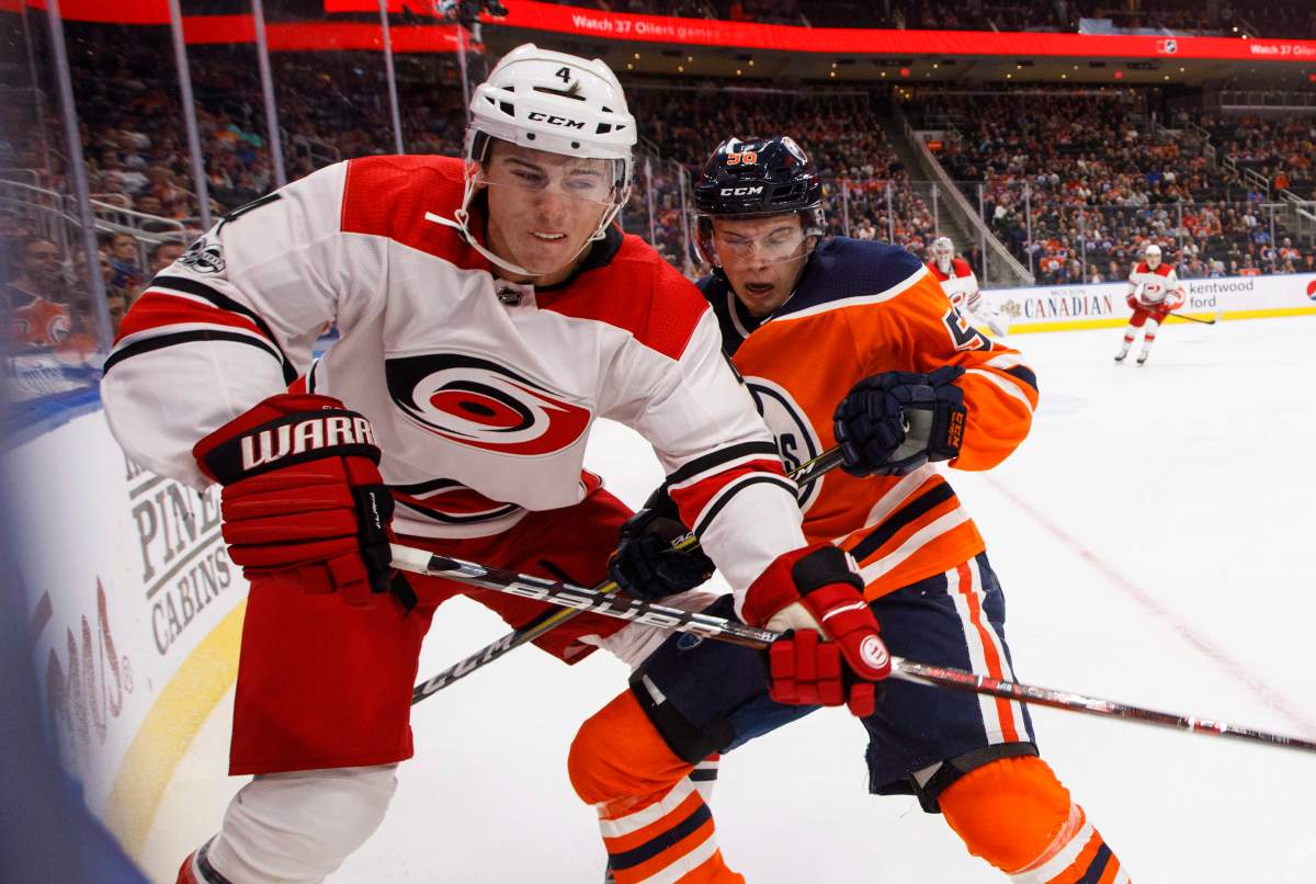 Carolina Hurricanes’ Haydn Fleury (4) and Edmonton Oilers’ Kailer Yamamoto (56) battle in the corner during second period NHL action in Edmonton, Alta., on Tuesday October 17, 2017.