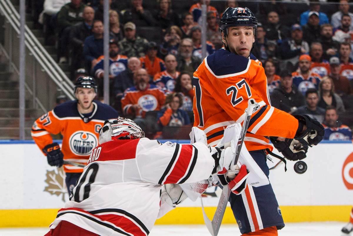 Carolina Hurricanes goalie Cam Ward (30) makes the save as Edmonton Oilers' Milan Lucic (27) screens during second period NHL action in Edmonton, Alta., on Tuesday October 17, 2017.